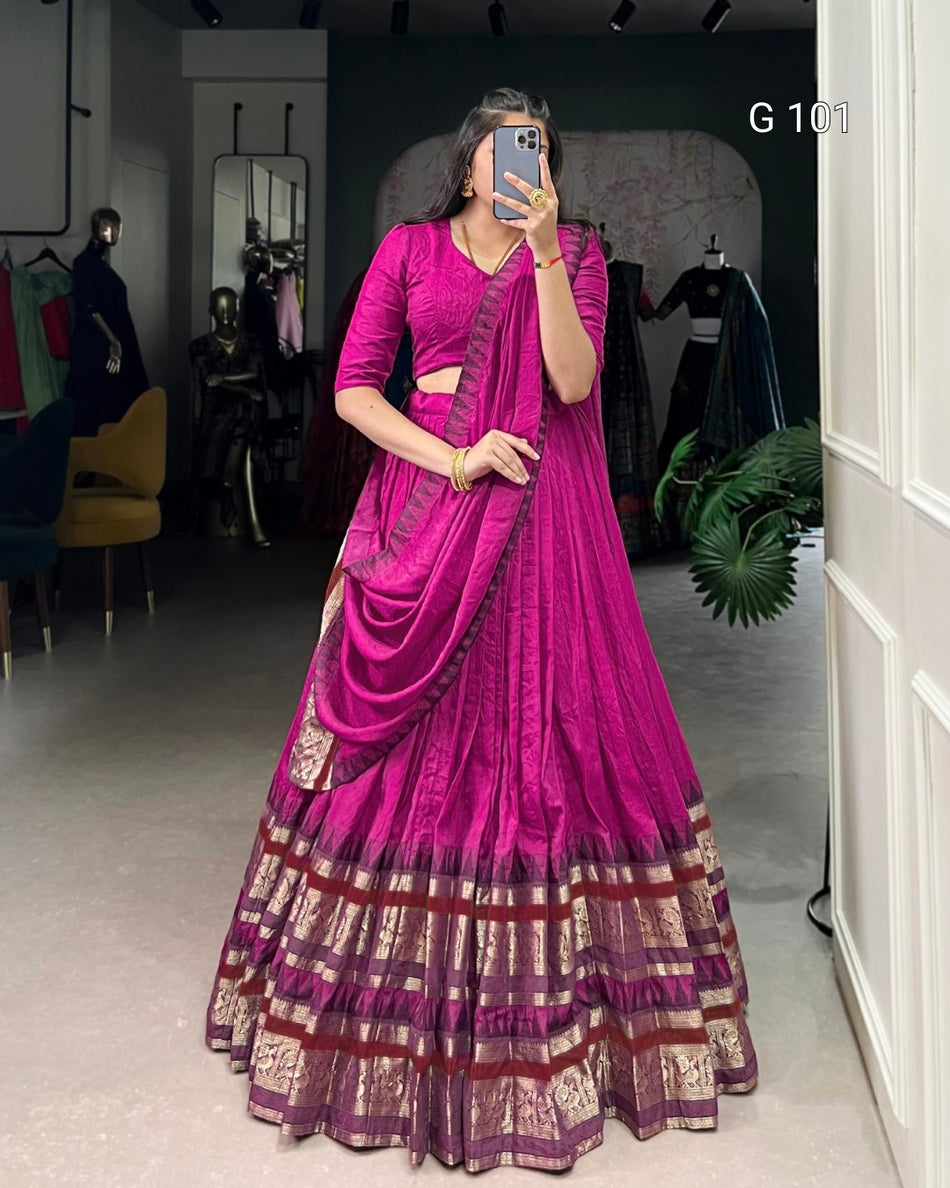 Woman wearing a vibrant pink saree with a dark background