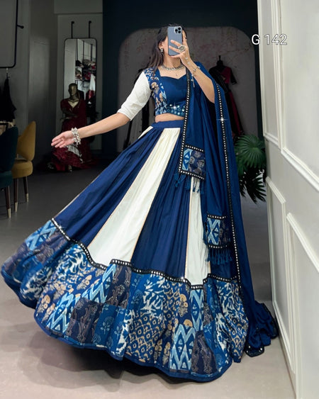 Woman wearing a blue and white traditional outfit with a matching dupatta in a room.