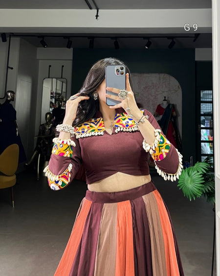 Woman taking a mirror selfie wearing a traditional outfit with colorful embroidery.