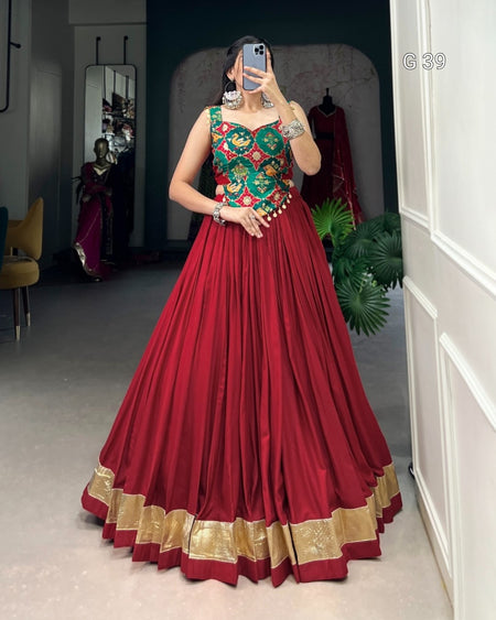 Woman wearing a red and green traditional outfit in a room with mirrors and decor.