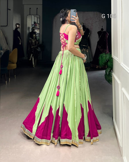 Person wearing a green and pink traditional outfit taking a mirror selfie.