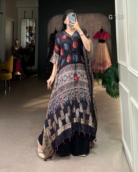 Person wearing a long, patterned dress in a room with mirrors and clothing in the background.
