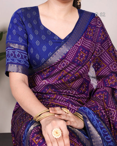 Person wearing a blue and purple patterned saree with a neutral background