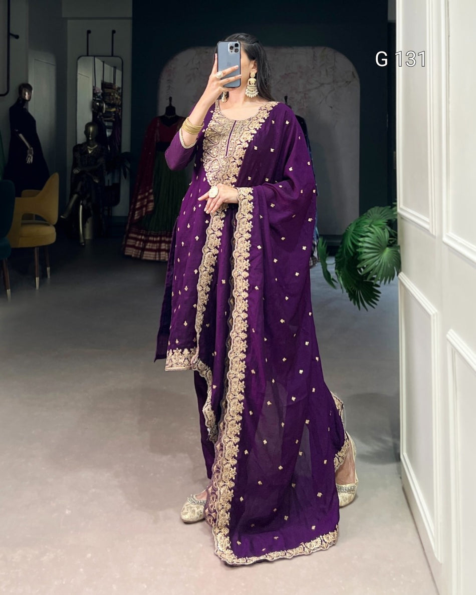 Person wearing a purple traditional outfit with gold embroidery in a room.