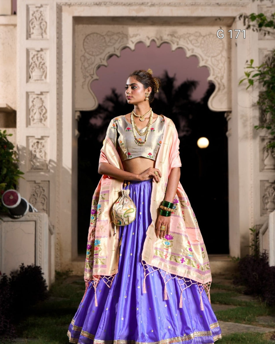 Woman in traditional Indian attire standing in front of an ornate architectural background