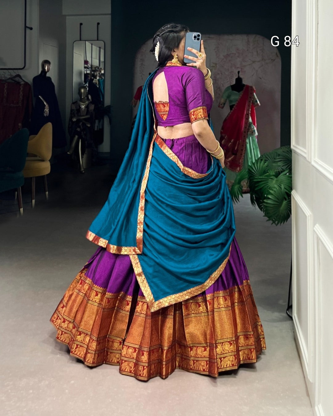 Person wearing a traditional multicolored saree in a room setting.