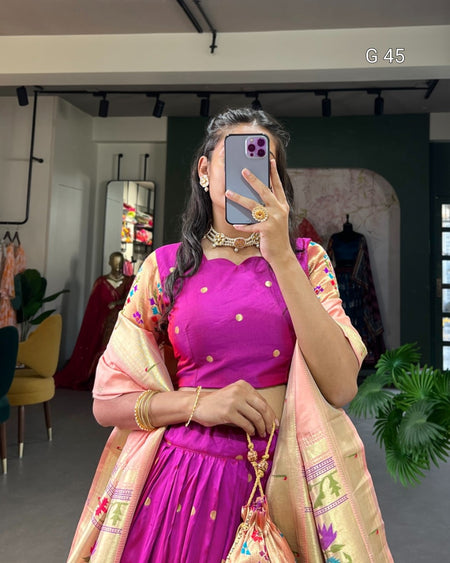 Woman taking a mirror selfie wearing a vibrant pink and gold traditional outfit.