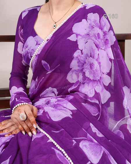 Purple saree with floral patterns worn by a person, with a focus on the fabric and design.