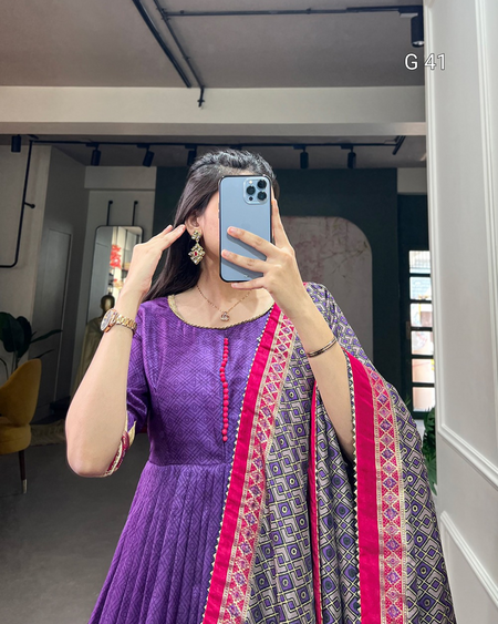 Person wearing a purple dress with a patterned dupatta in an indoor setting