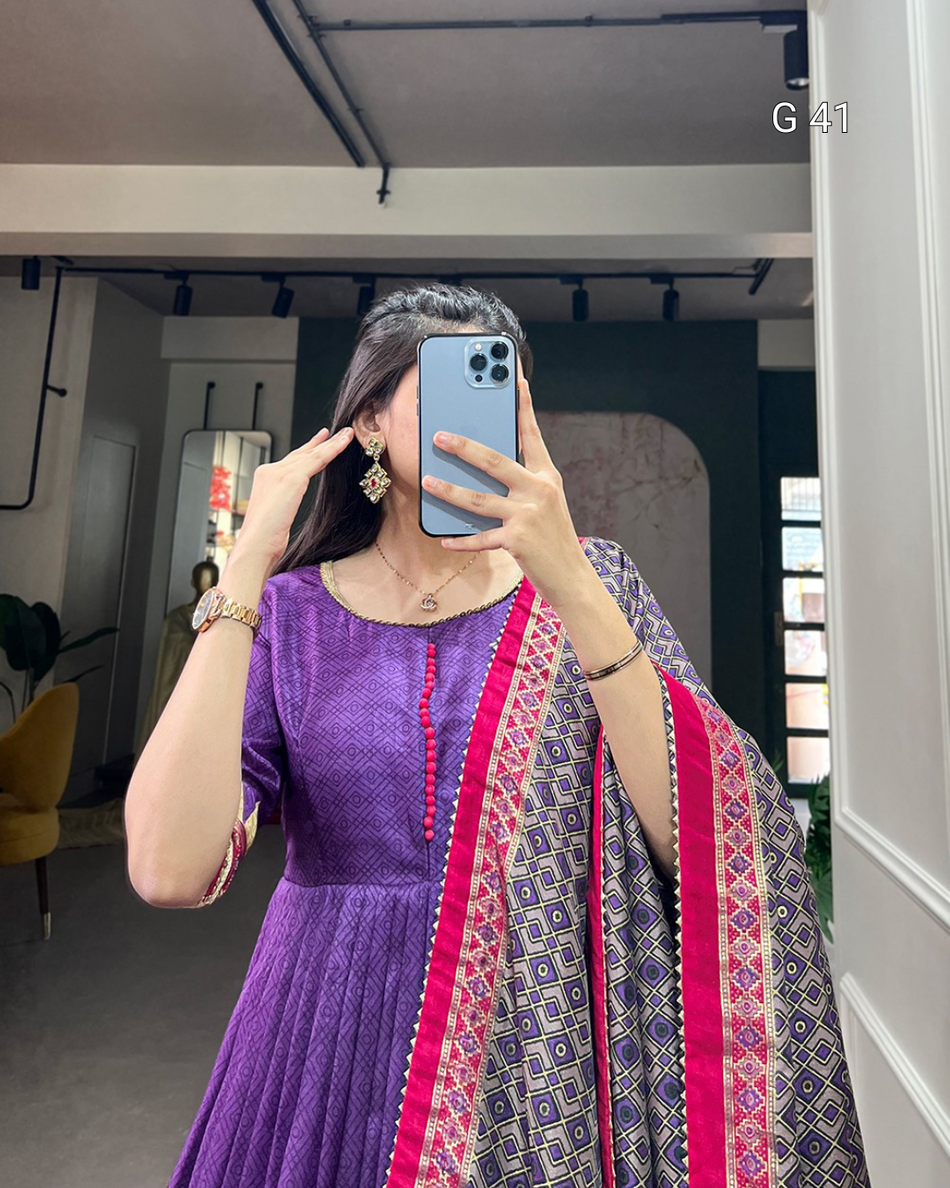 Person wearing a purple dress with a patterned dupatta in an indoor setting