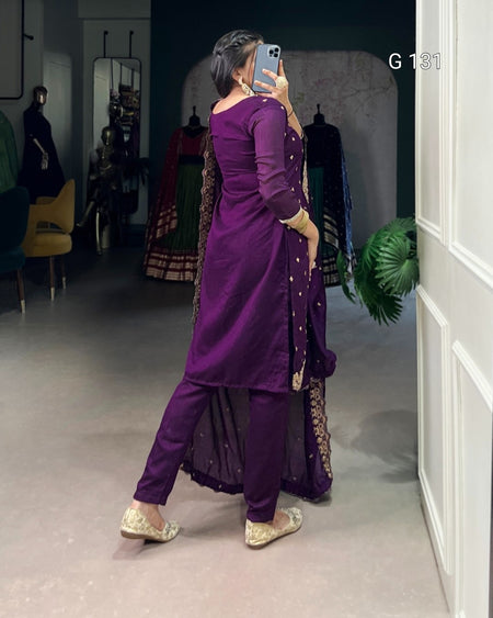 Person wearing a purple traditional outfit with gold details in a store setting.