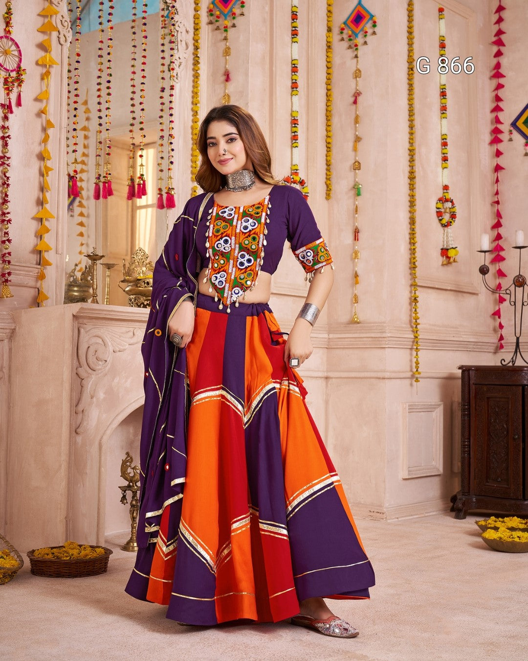 Woman wearing a colorful traditional outfit in an ornate room.