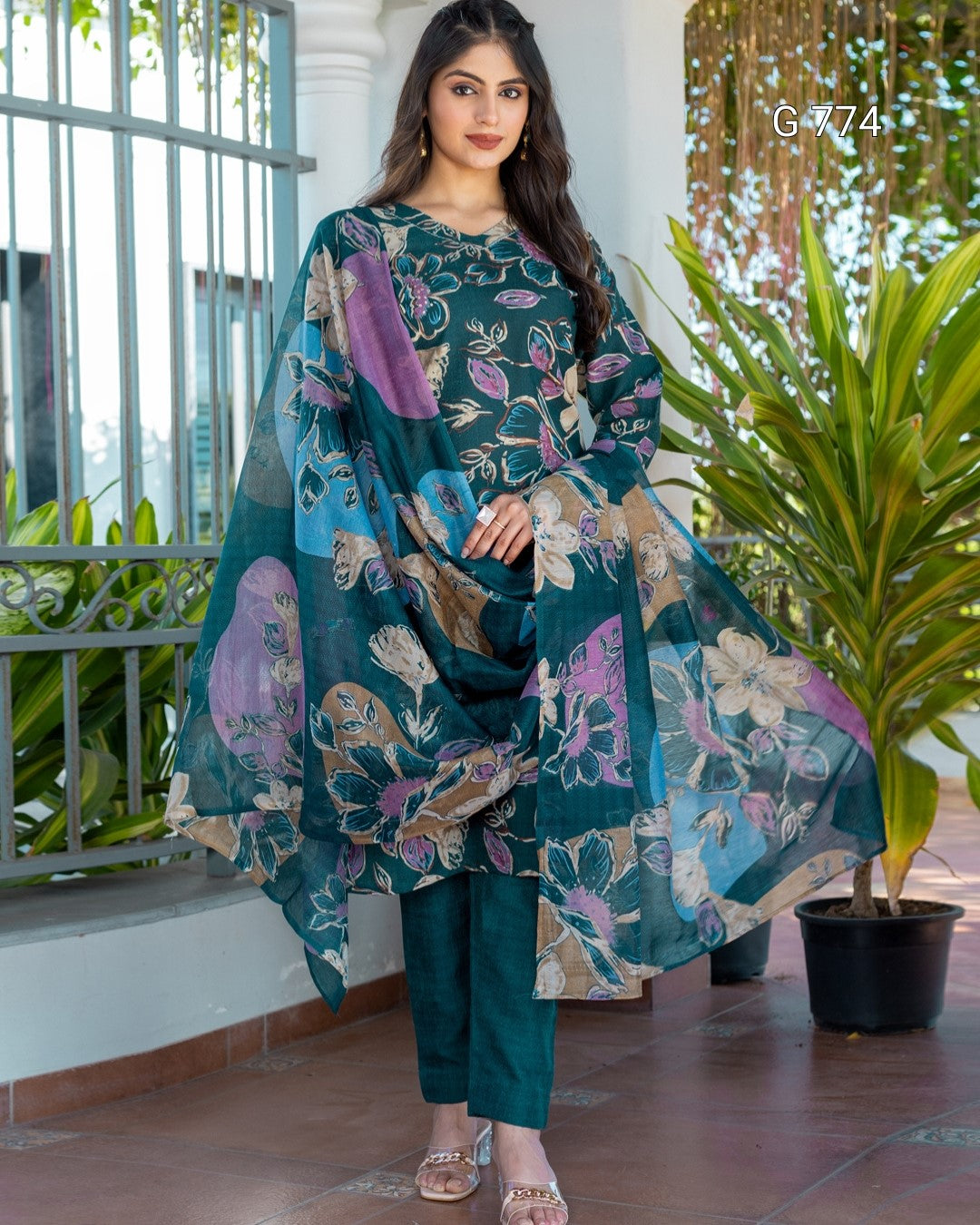 Woman wearing a floral dress with a plant in the background