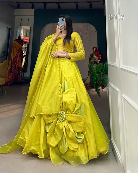 Person wearing a bright yellow traditional outfit with a large bow in a room.