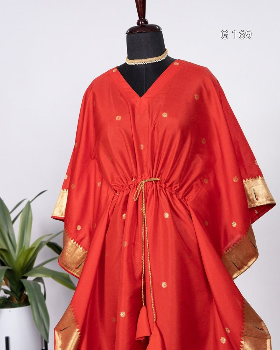 Red dress with gold accents on a mannequin against a white background