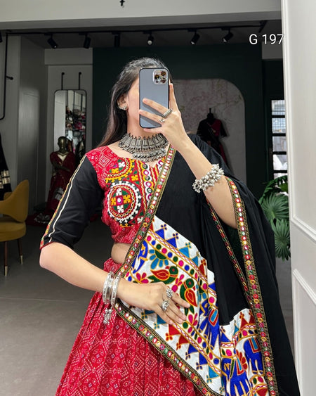 Person wearing a colorful traditional outfit with intricate designs indoors.
