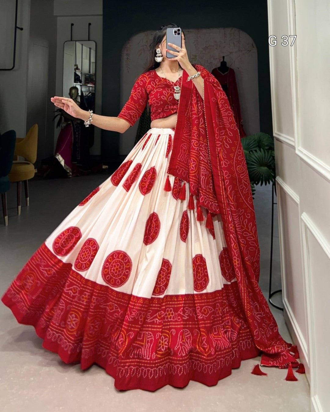 Red and white traditional outfit with a matching dupatta being modeled indoors.