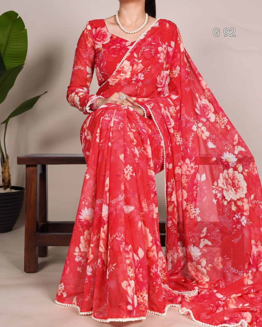 Red floral saree with a matching blouse on a neutral background