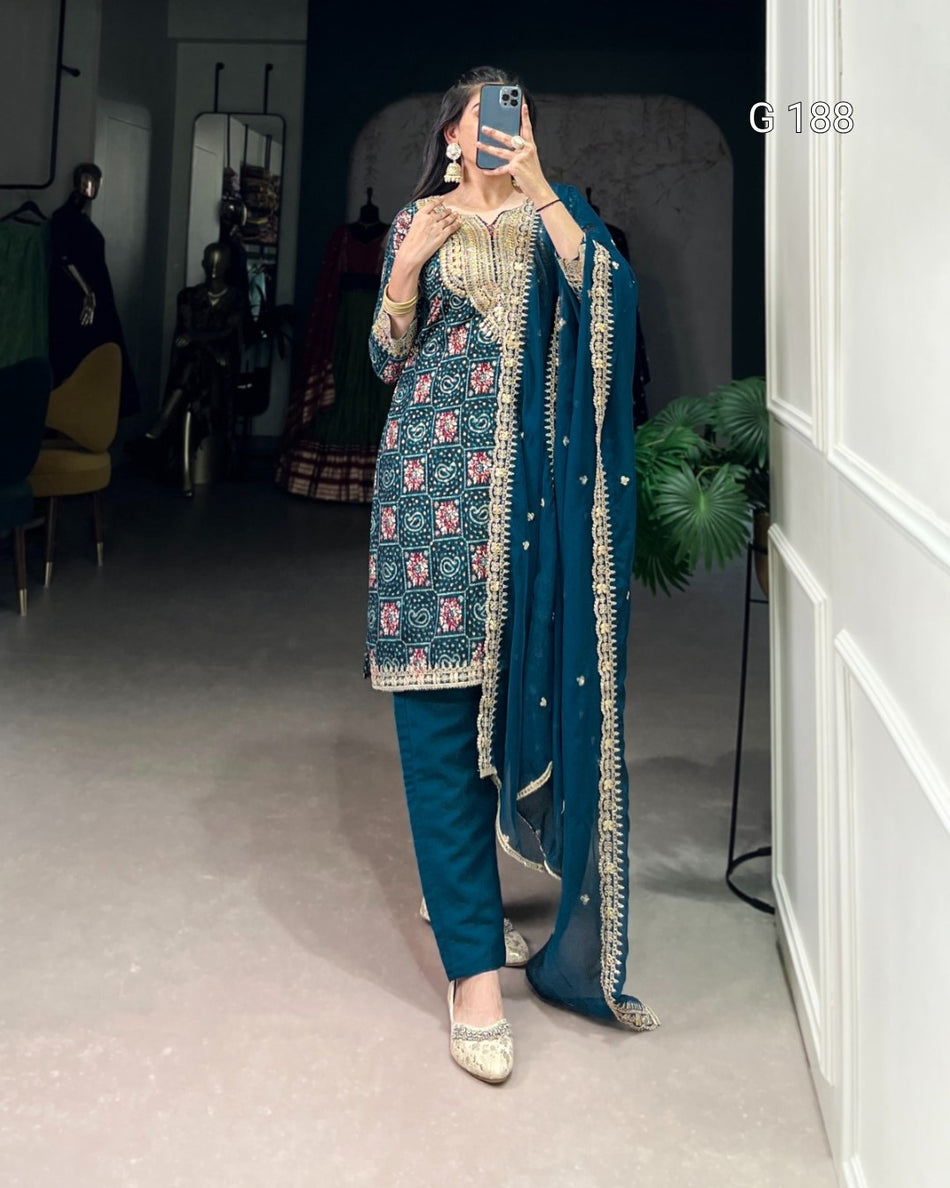 Person wearing a traditional outfit with a blue and gold design in an indoor setting.