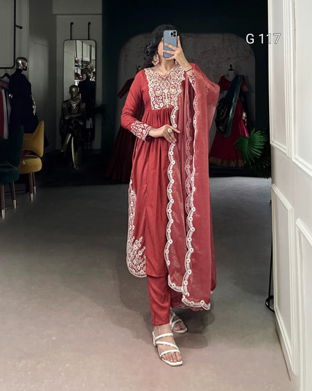 Person wearing a red traditional outfit with white embroidery in a room.