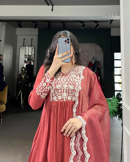 Person wearing a red dress with white lace details in a room.