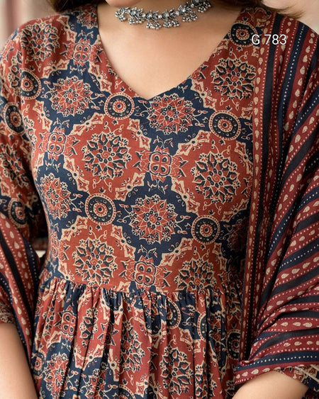 Close-up of a patterned dress with intricate designs in red and blue.