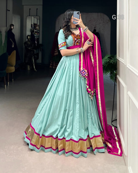 Woman in a light blue traditional outfit with a pink dupatta taking a mirror selfie.