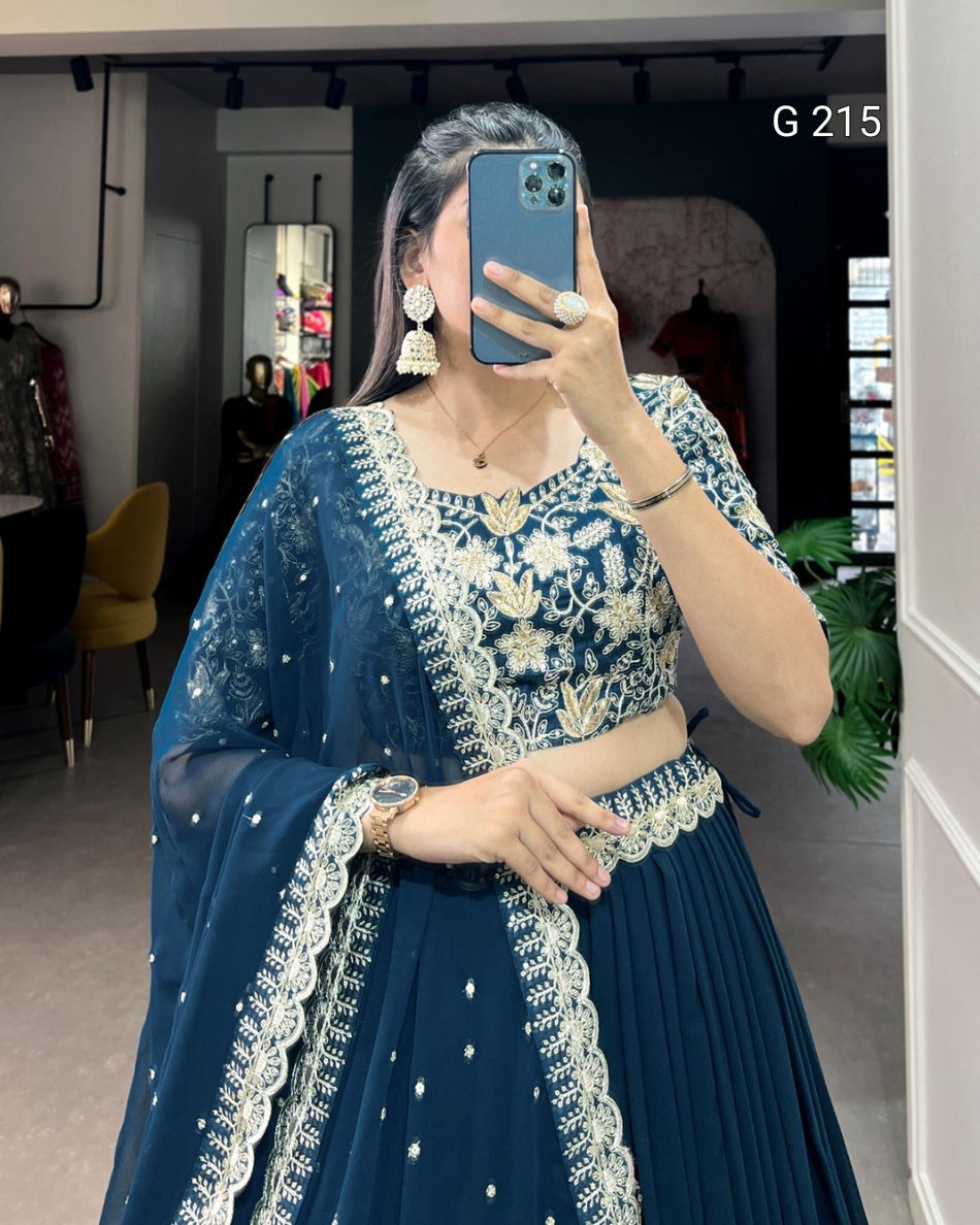 Person wearing a blue embroidered outfit taking a mirror selfie.
