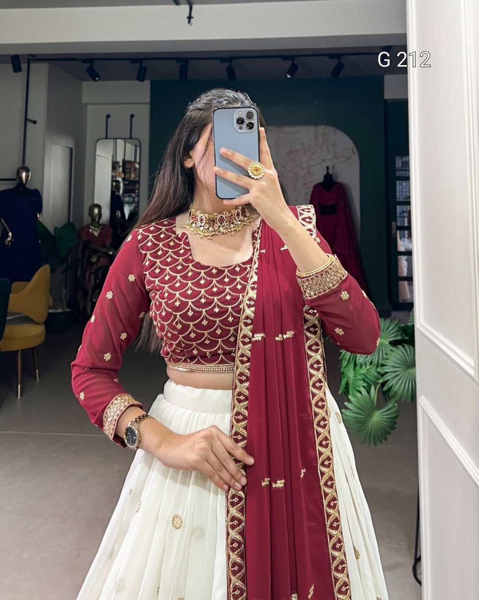 Person wearing a traditional outfit with a red and white saree in a room.