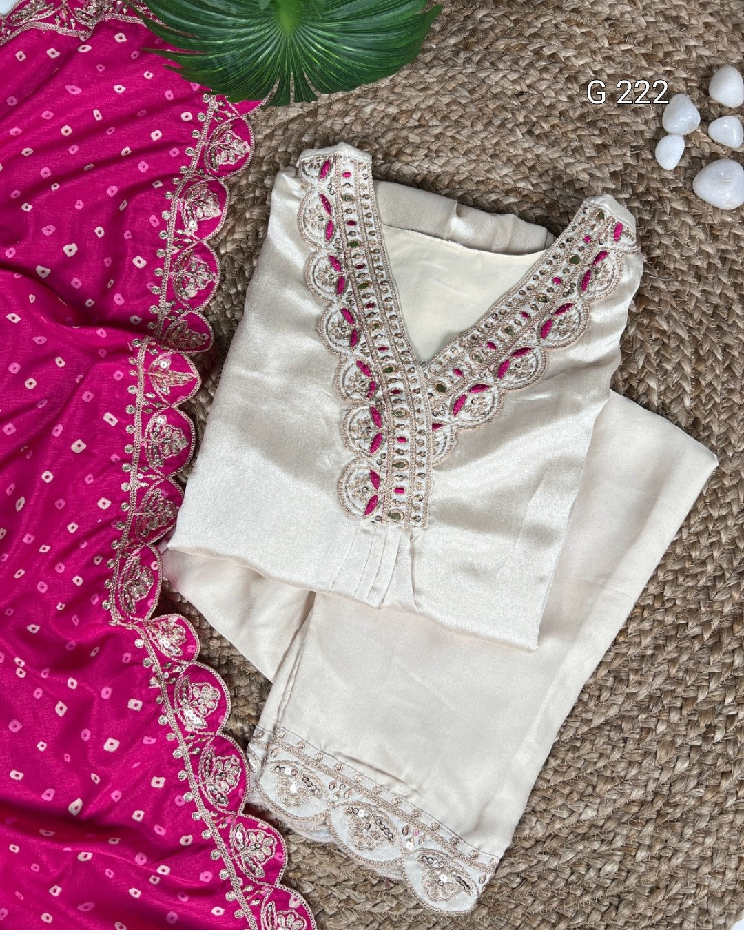 White blouse with intricate red and silver embroidery on a textured surface.