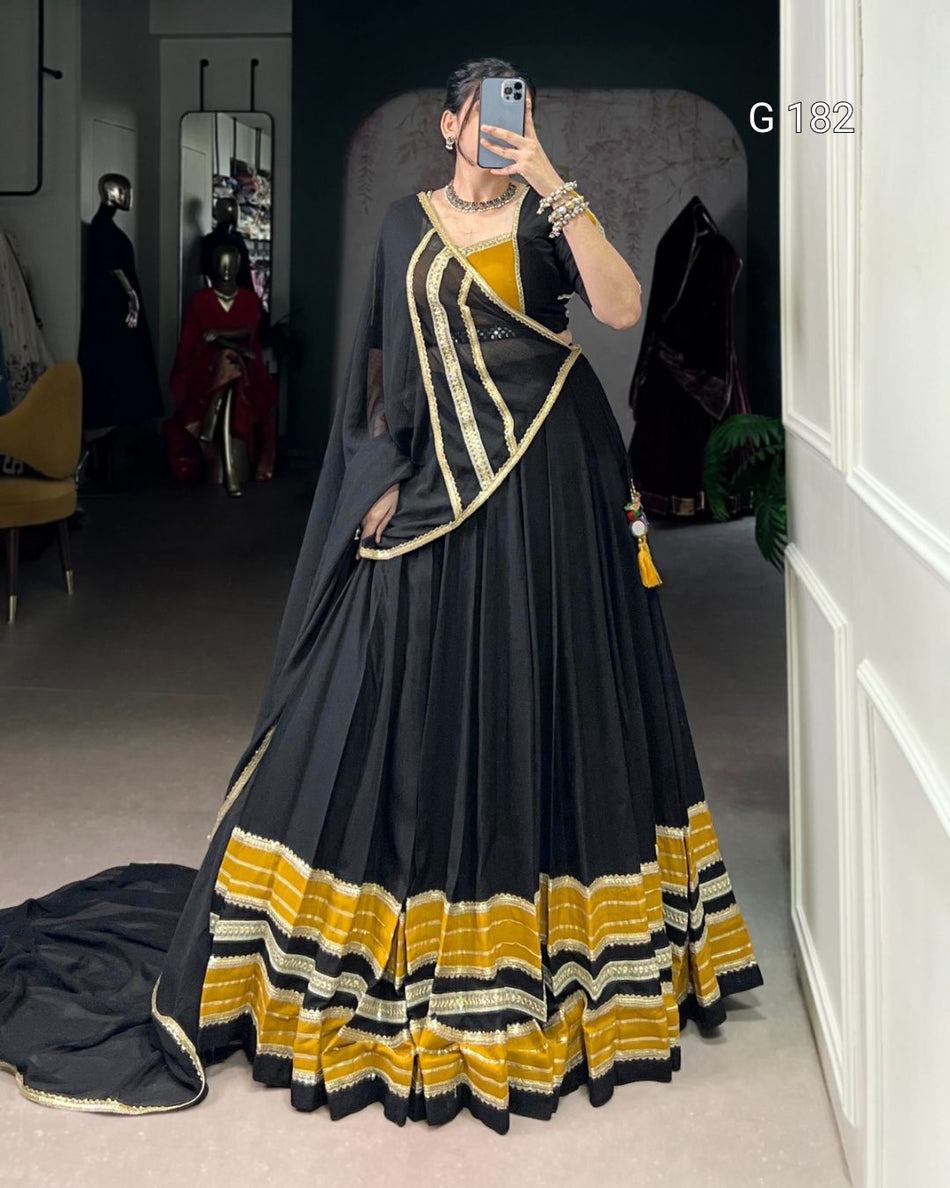 Person wearing a black and yellow traditional outfit in a room.