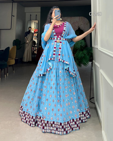 Woman in a blue floral dress taking a mirror selfie in a room.