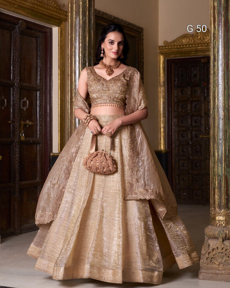 Woman in a traditional gold outfit standing in a decorated room with ornate doors.