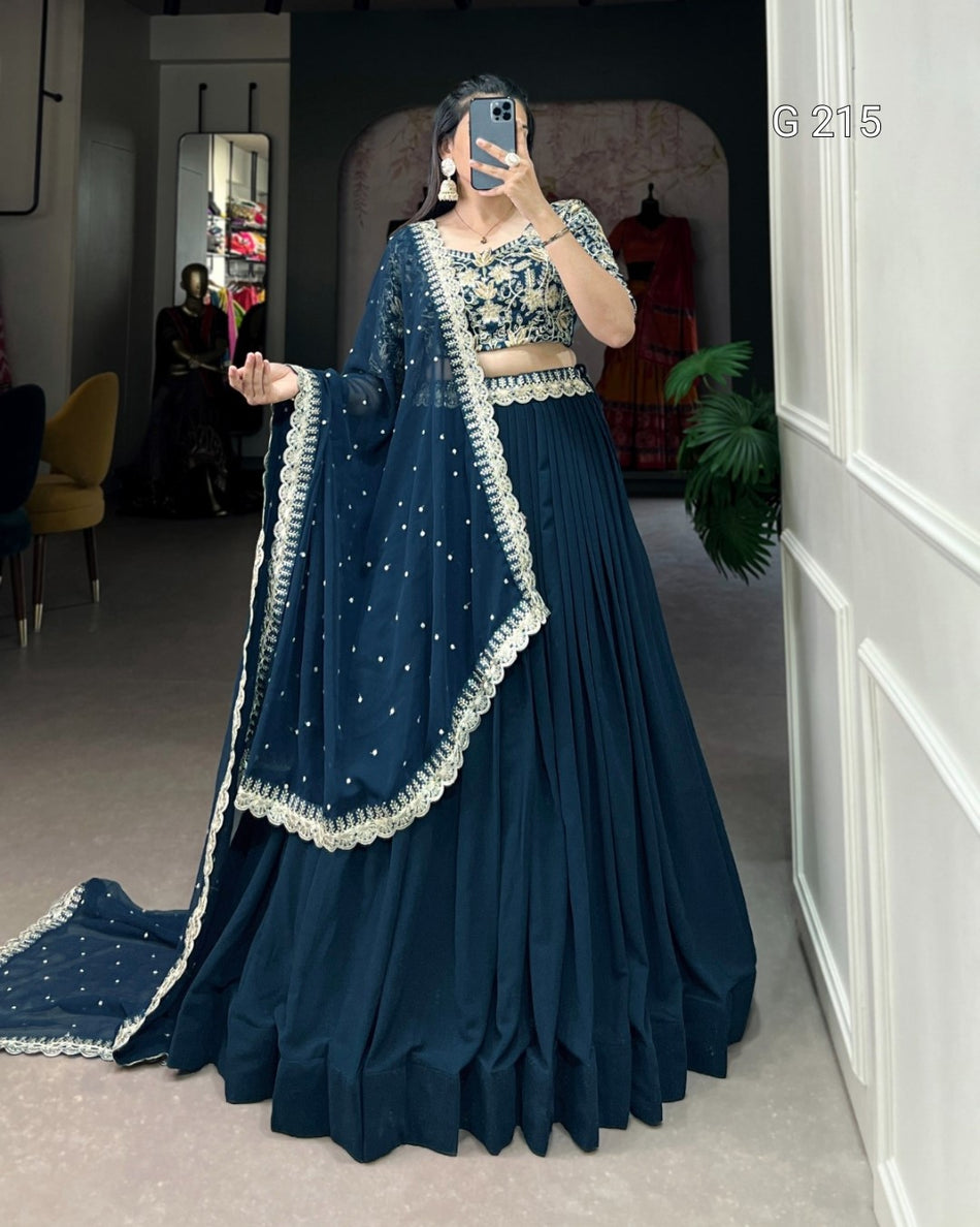Person wearing a traditional blue outfit with white details in an indoor setting.