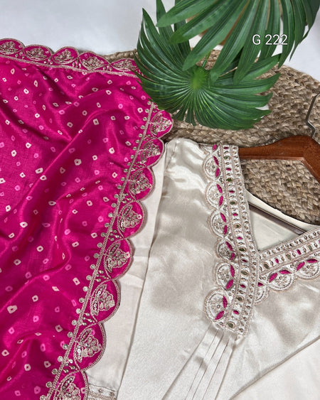 Embroidered pink and white fabric with a plant in the background