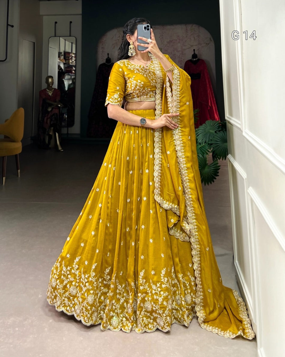 Woman in a yellow traditional outfit with floral patterns taking a mirror selfie.