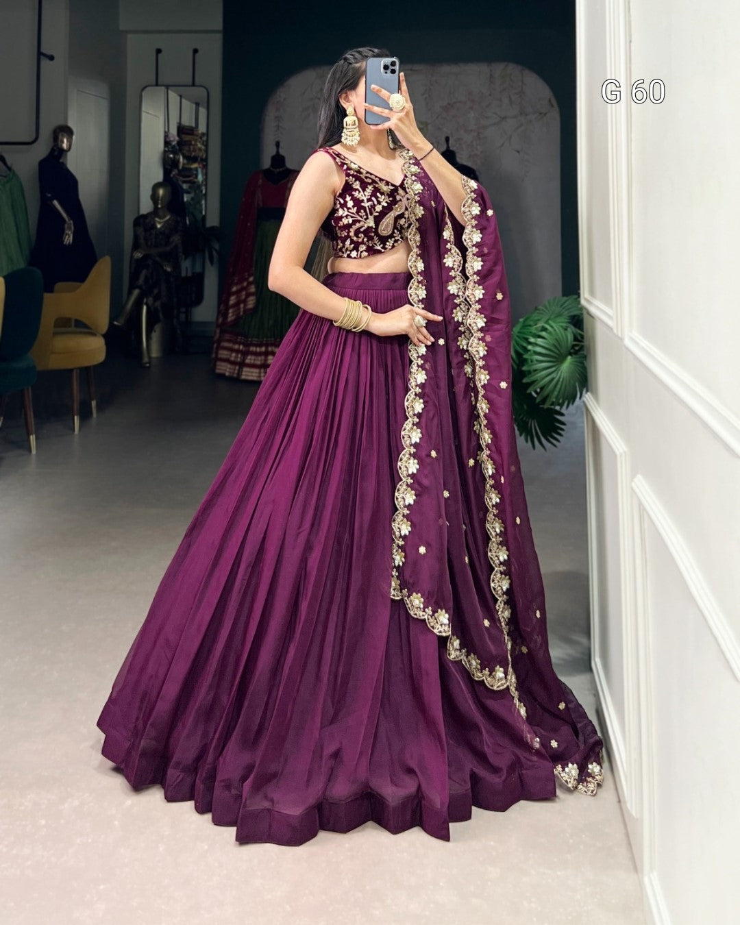 Woman in a purple traditional outfit with gold details in a room.