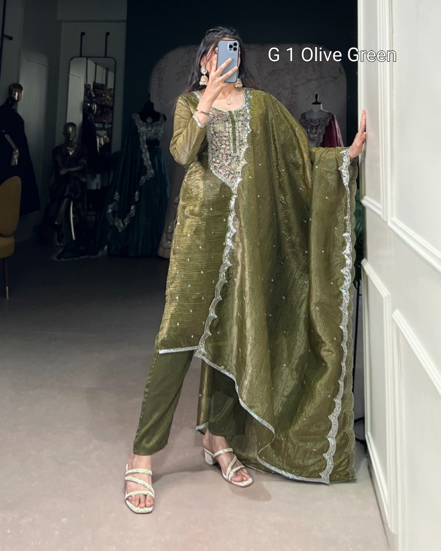 Person wearing an olive green traditional outfit with a dupatta in a fitting room.