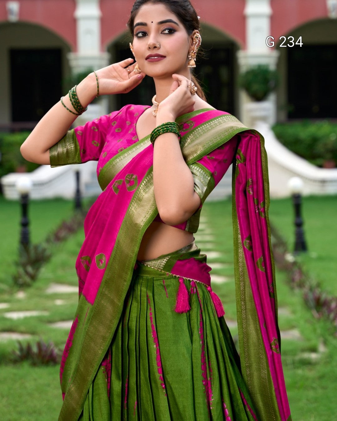 Woman wearing a pink and green saree in an outdoor setting