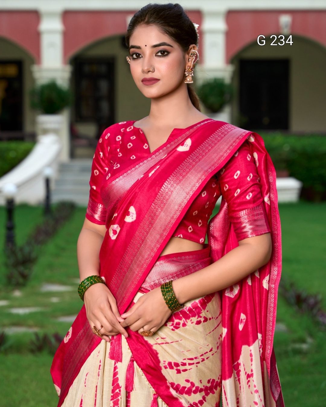 Woman wearing a red saree with a white pattern in an outdoor setting
