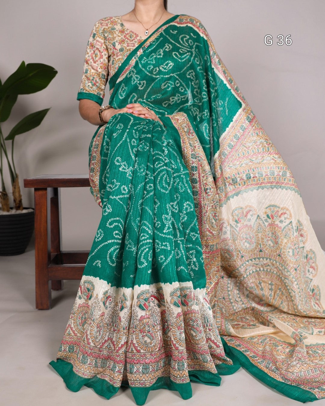 Green and beige saree with intricate patterns on a neutral background
