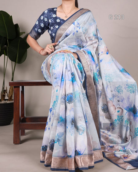 Woman wearing a blue and white floral saree with a neutral background
