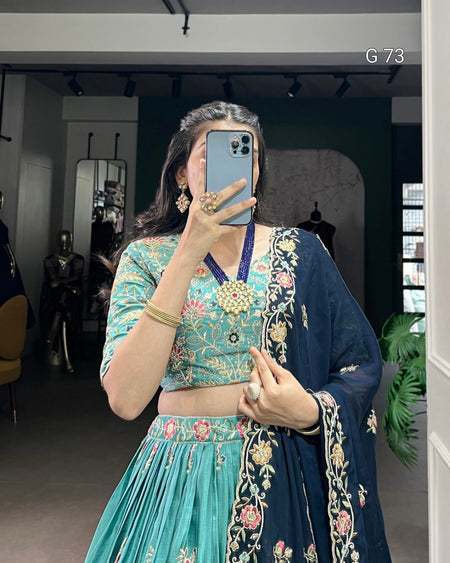 Person wearing a traditional outfit with floral patterns in a room setting.