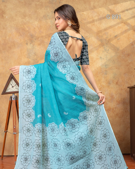 Woman wearing a blue saree with white floral patterns against a brown background
