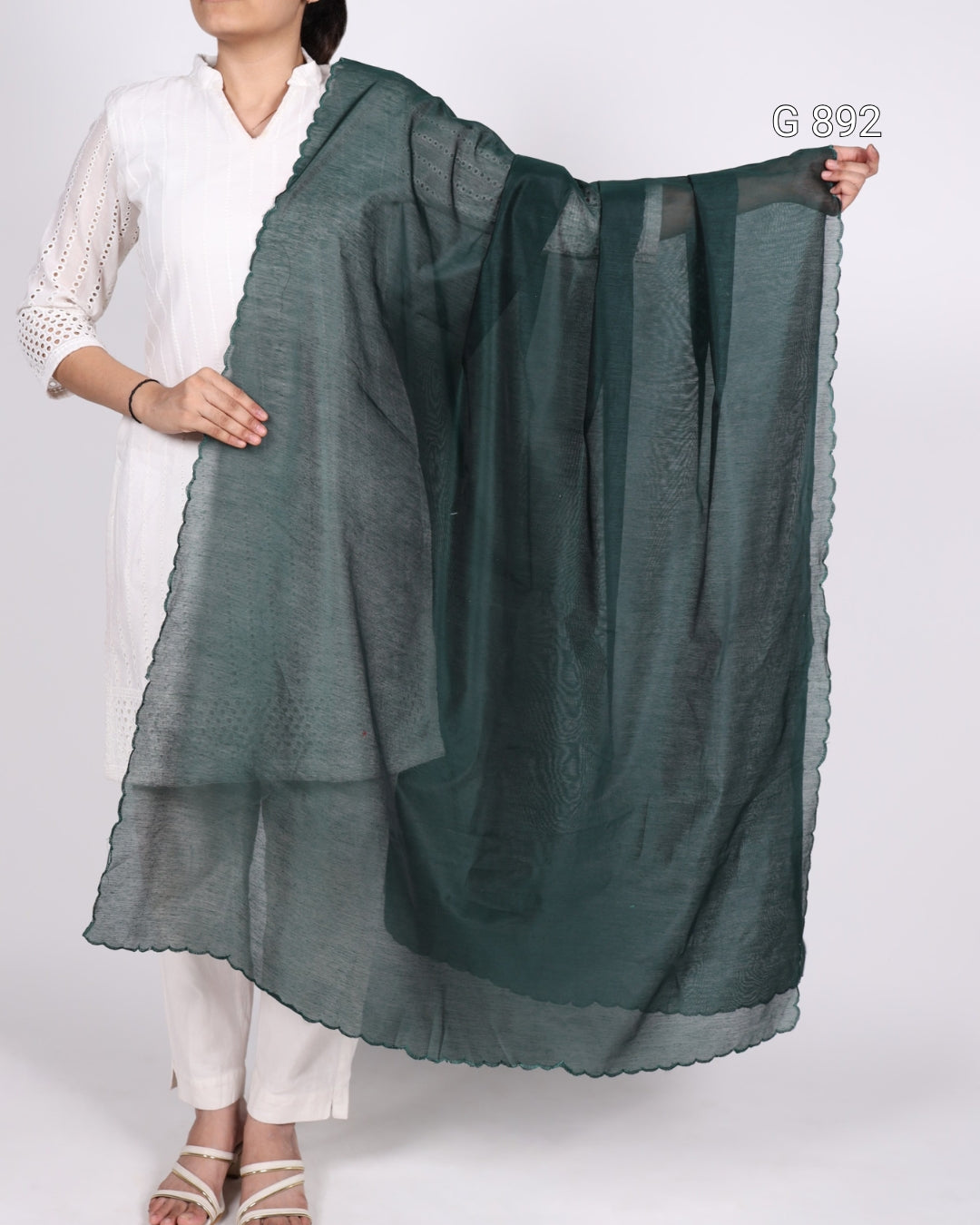 Person holding a dark green scarf against a white background