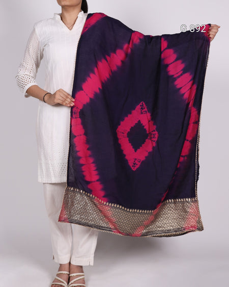 Person holding a dark blue and pink patterned scarf against a white background