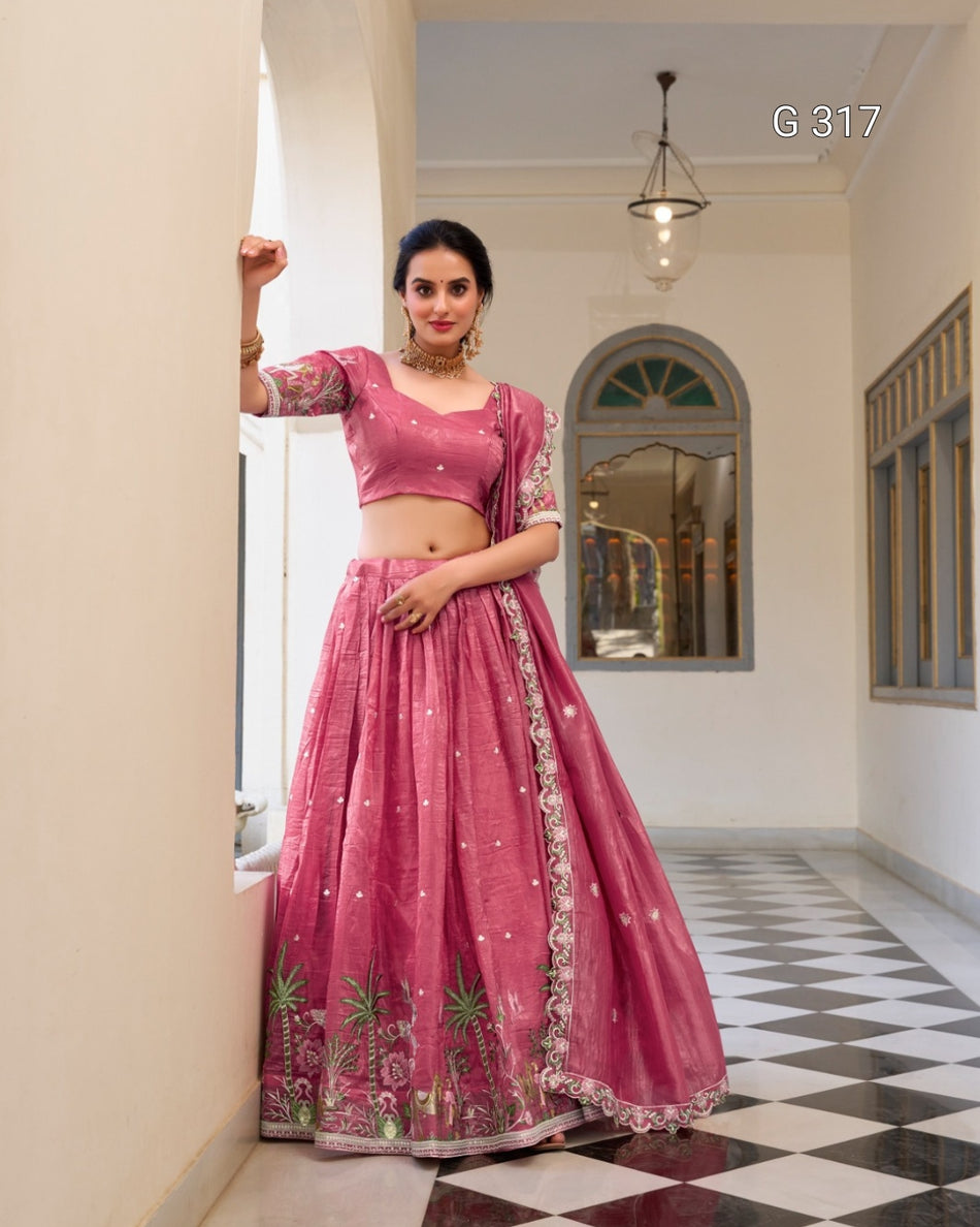 Woman in a pink traditional outfit standing in a room with checkered floor and white walls.