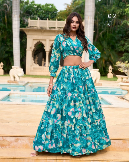 Woman in a teal floral outfit standing by a pool with a garden background