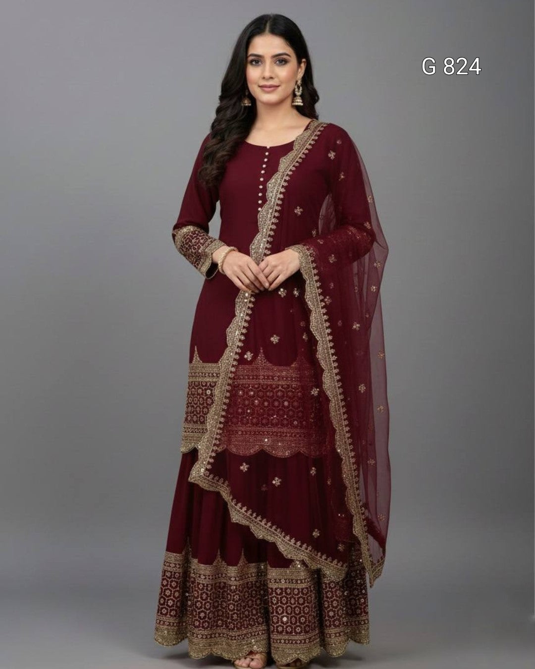 Woman wearing a maroon traditional outfit with gold embroidery on a gray background