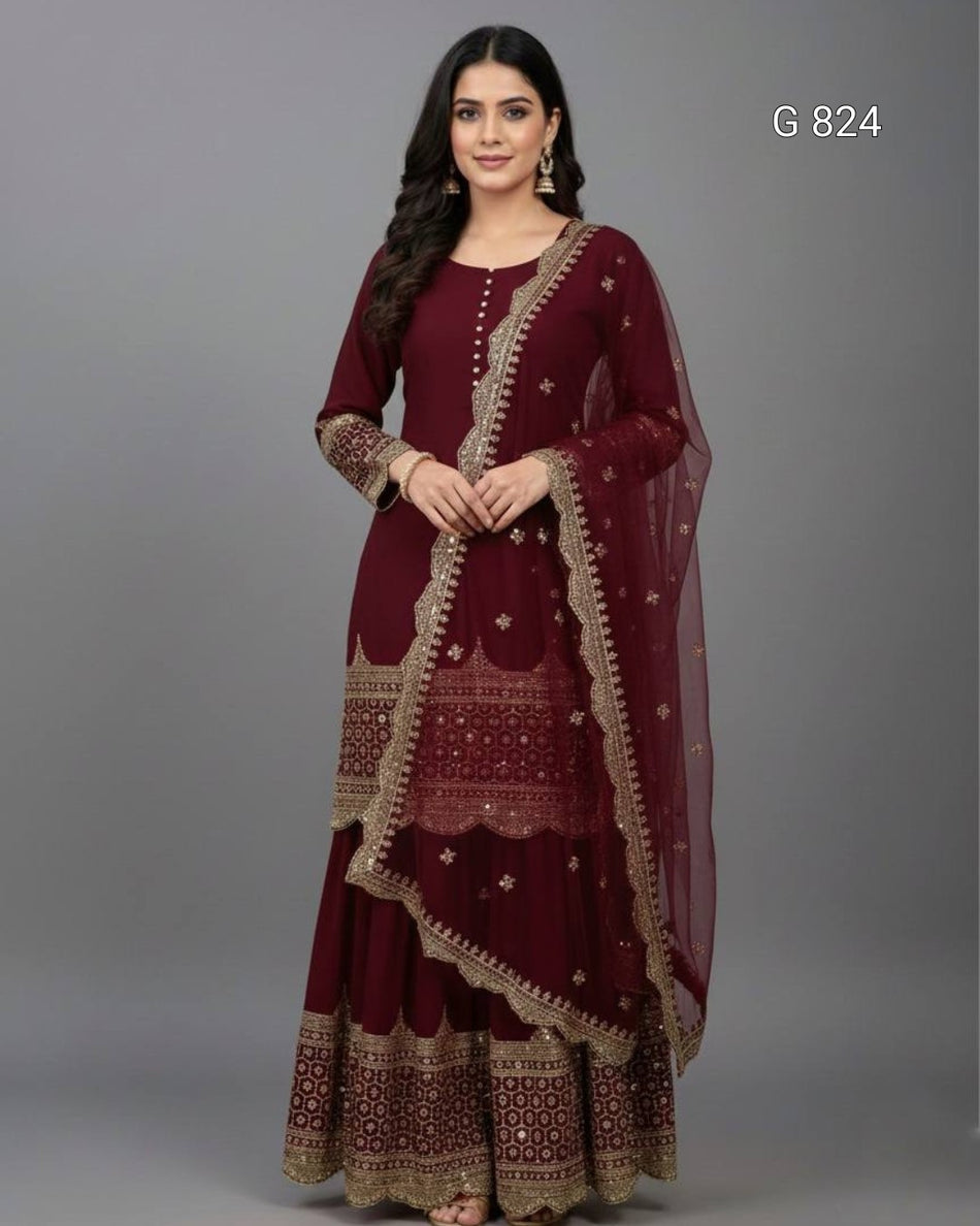 Woman wearing a maroon traditional outfit with gold embroidery on a gray background